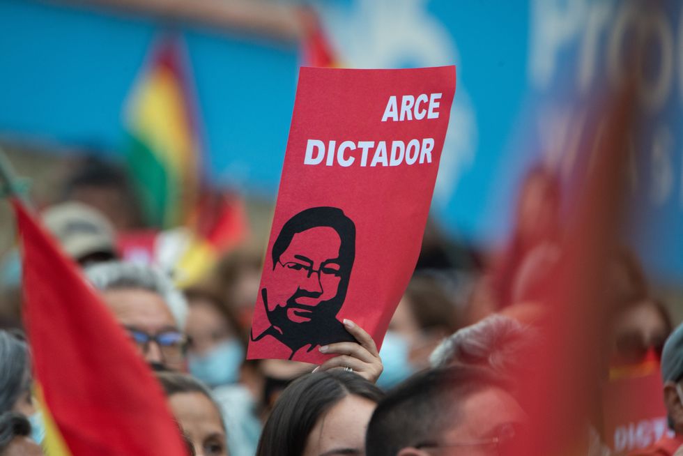 photo of someone holding a poster "Arce Dictador"