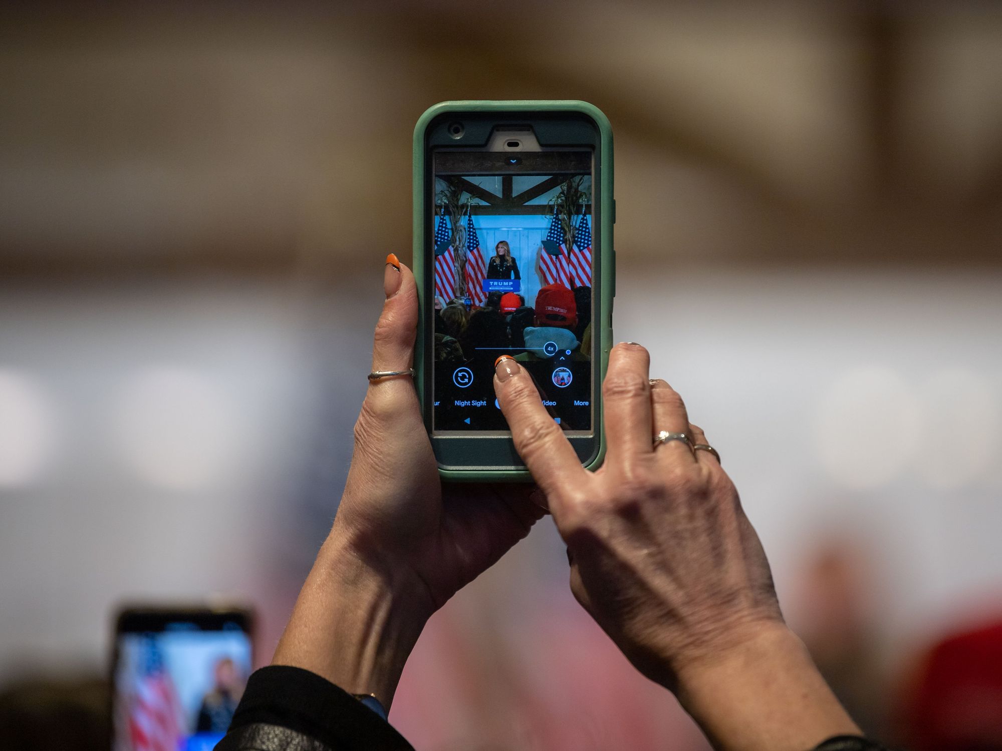 Photo of someone taking a video of Melania Trump at a rally.