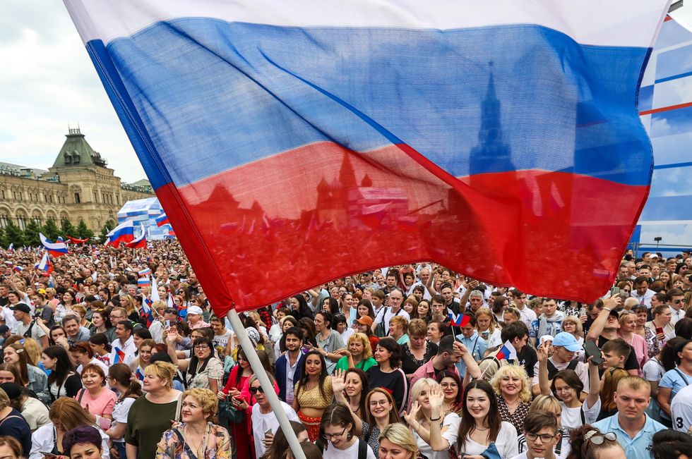 Photo of spectators waving a Russian national flag at a concert marking Russia Day