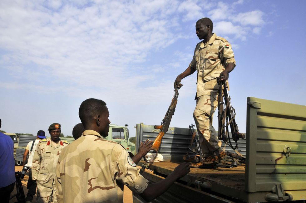 Photo of Sudanese soldiers collecting weapons from a truck.