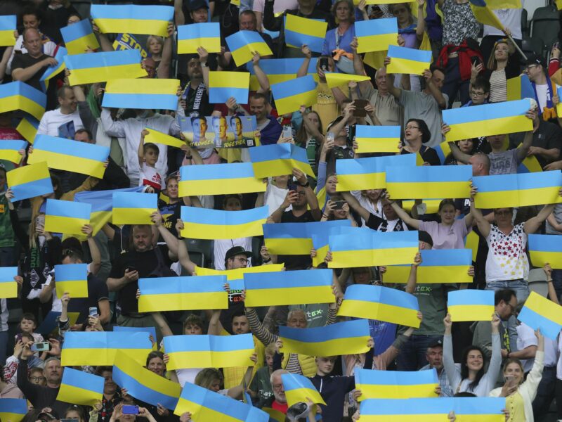 Photo of supporters hold Ukrainian flags in honor of the victims of the war in Ukraine​