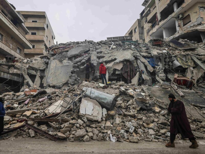 Photo of Syrian civilians inspecting a destroyed residential building in Idlib after the earthquake