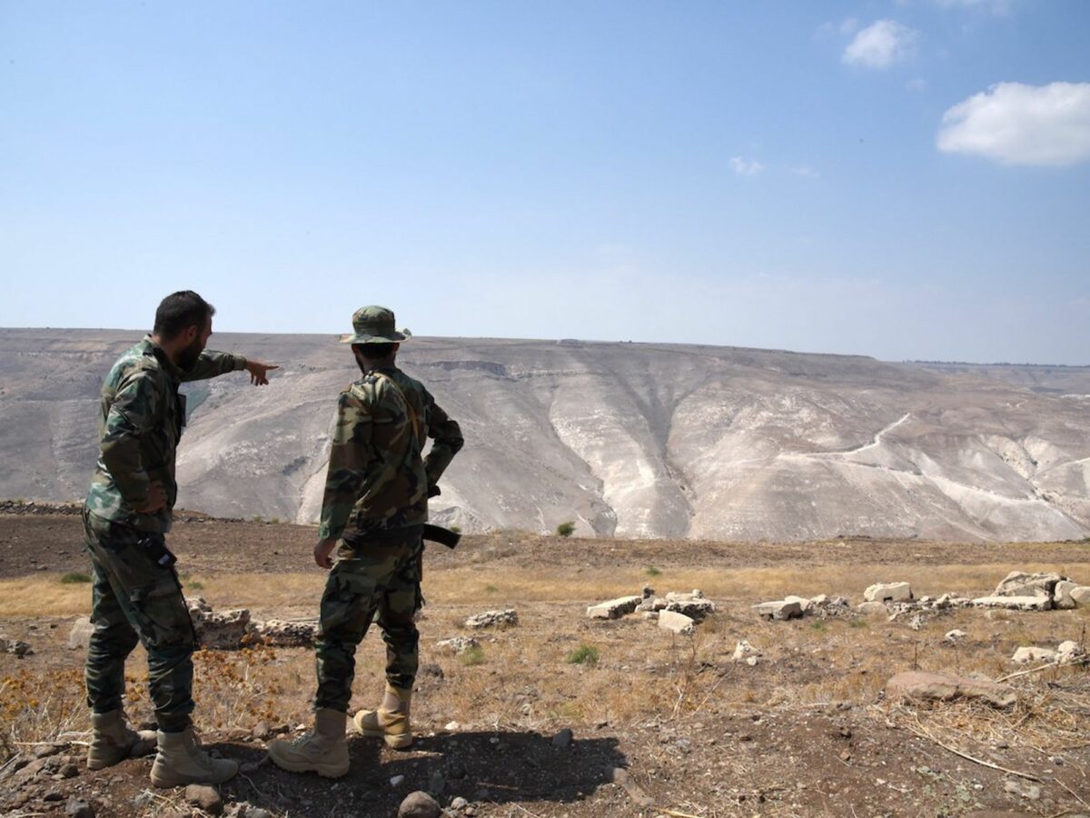 Photo of Syrian soldiers looking at ground zero, a triangle of Syrian territory slicing between Jordan and the Israeli-occupied Golan Heights.