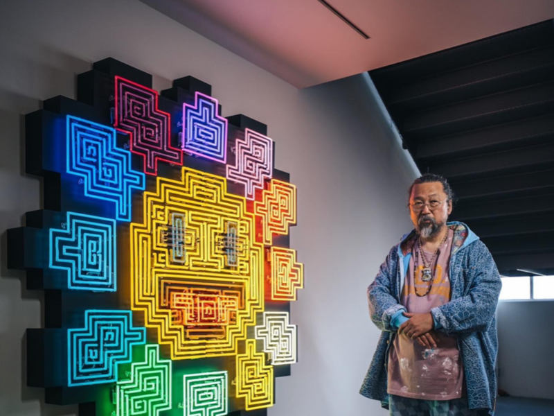 Photo of Takashi Murakami in front of his art works