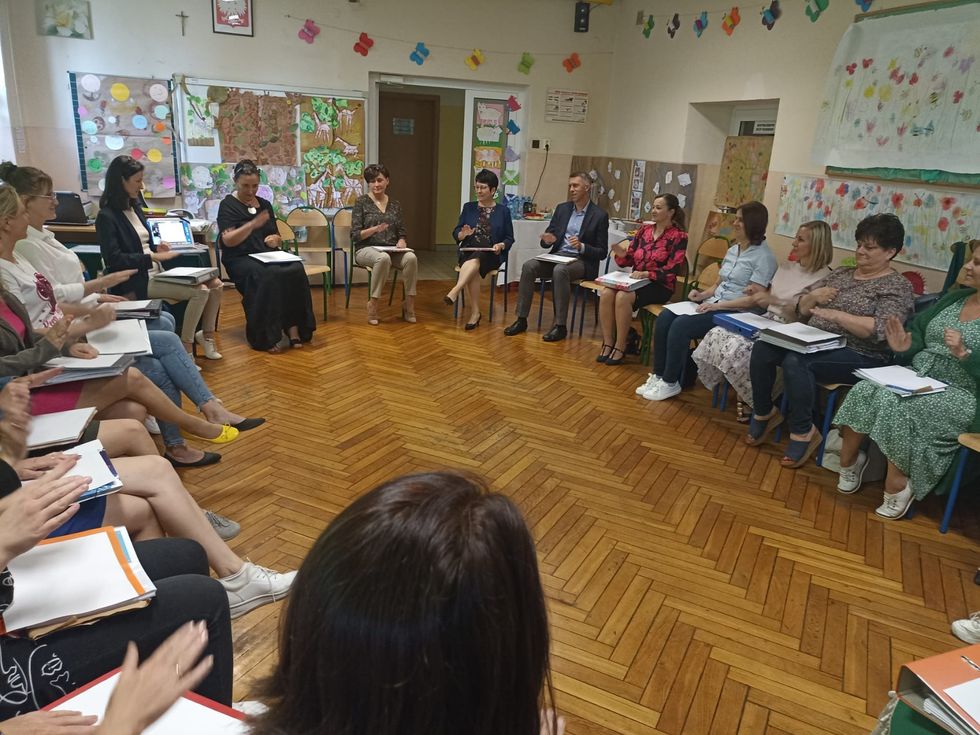 photo of teachers meeting in a circle of chairs