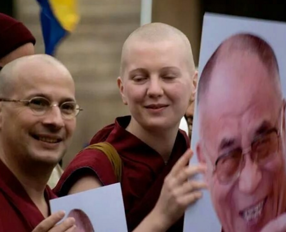 Photo of Tenzin Peljor during a protest in support of Tibet, with a placard showing a picture of the Dalai Lama