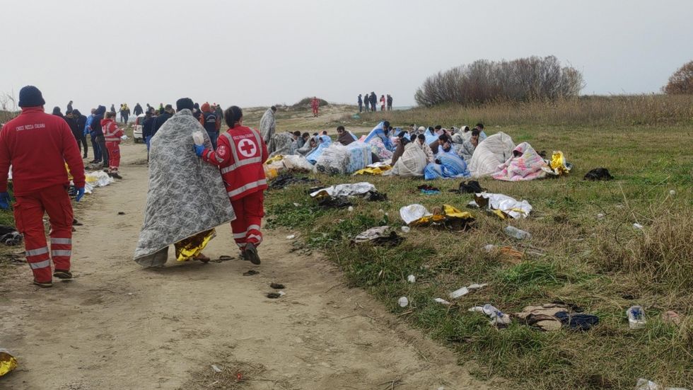 Photo of the ​Red Cross personnel helping survivors after they washed ashore following a shipwreck, at a beach near Steccato di Cutro, Crotone province, southern Italy.