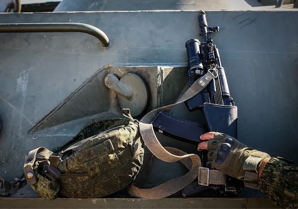 Photo of the hand of a soldier seizing a rifle