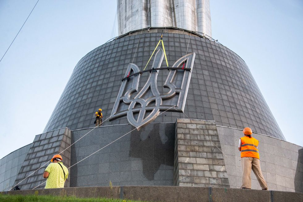 Photo of the installation of the coat of arms of Ukraine on the Motherland Monument in Kyiv, as part of the decommunization and derussification process in Ukraine