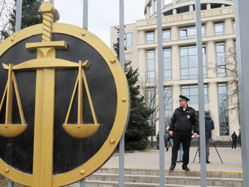 photo of the scales of justice with policeman behind