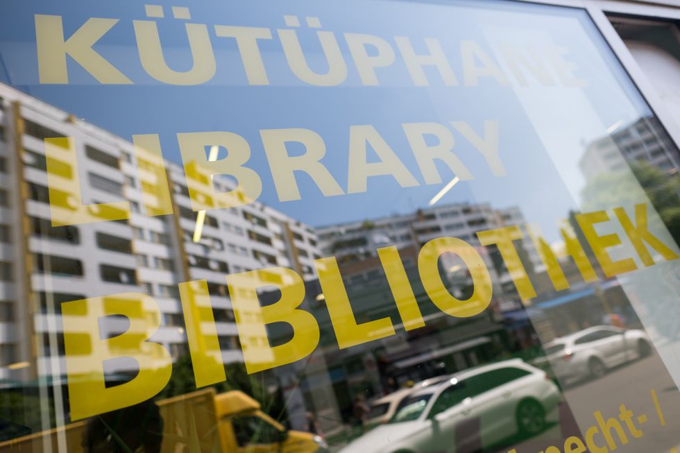 Photo of the word "library" in Turkish, English and German is written on the window of the Wilhelm Liebknecht