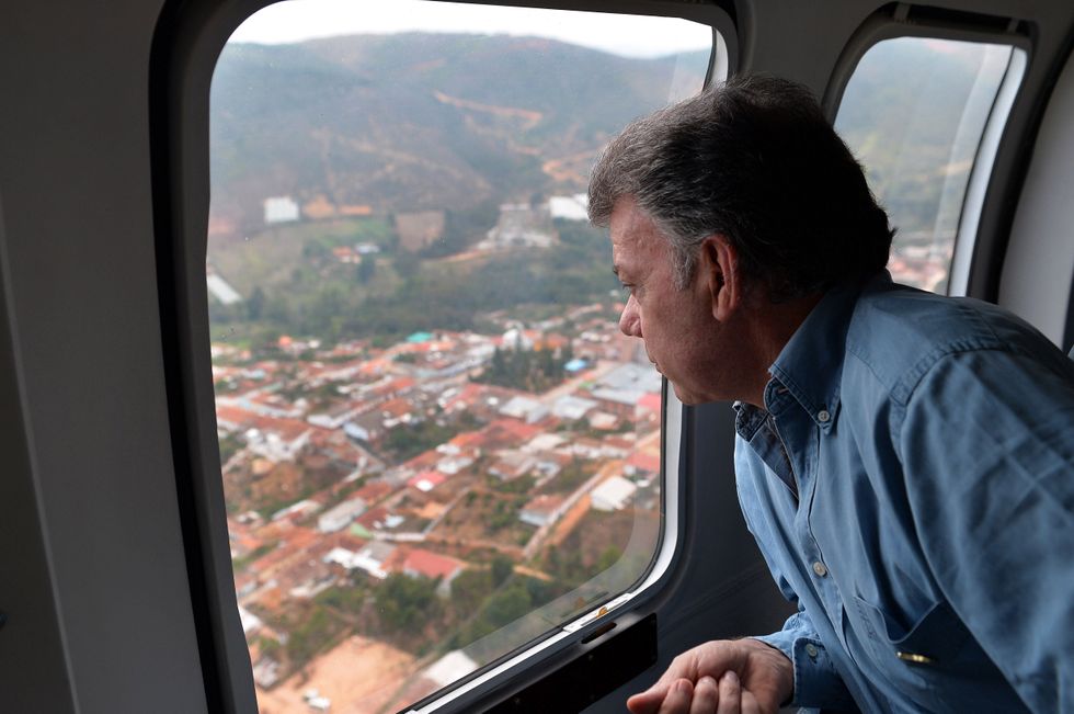 Photo of then ​Colombian President Juan Manuel Santos looking out of a plane window, on his way to Betualia, Colombia, after it was hit by an earthquake in 2015