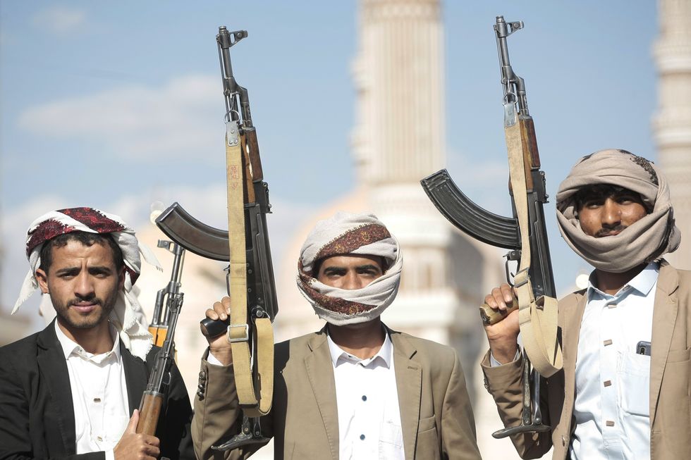 photo of three men belonging to Yemen's Houthi militia, holding rifles