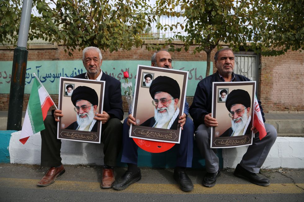 photo of three men holding posters of khamenei