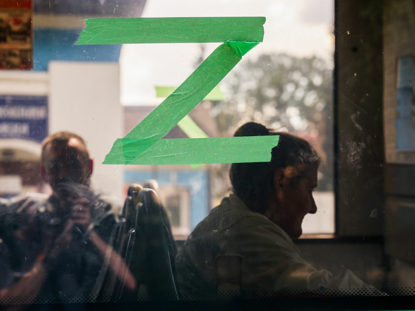 Photo of three people sat on a bus as they await evacuation near Kursk, Russia