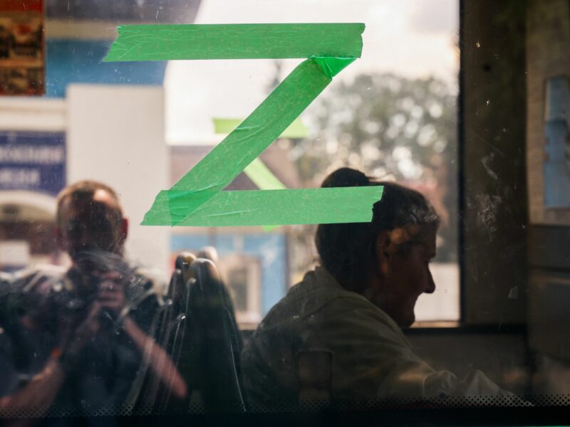 Photo of three people sat on a bus as they await evacuation near Kursk, Russia