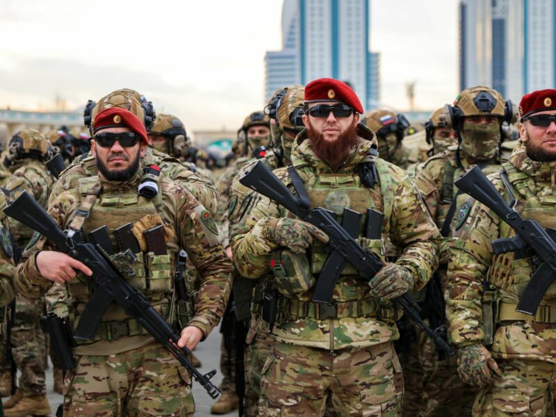 photo of three soldiers with automatic weapons and red berets