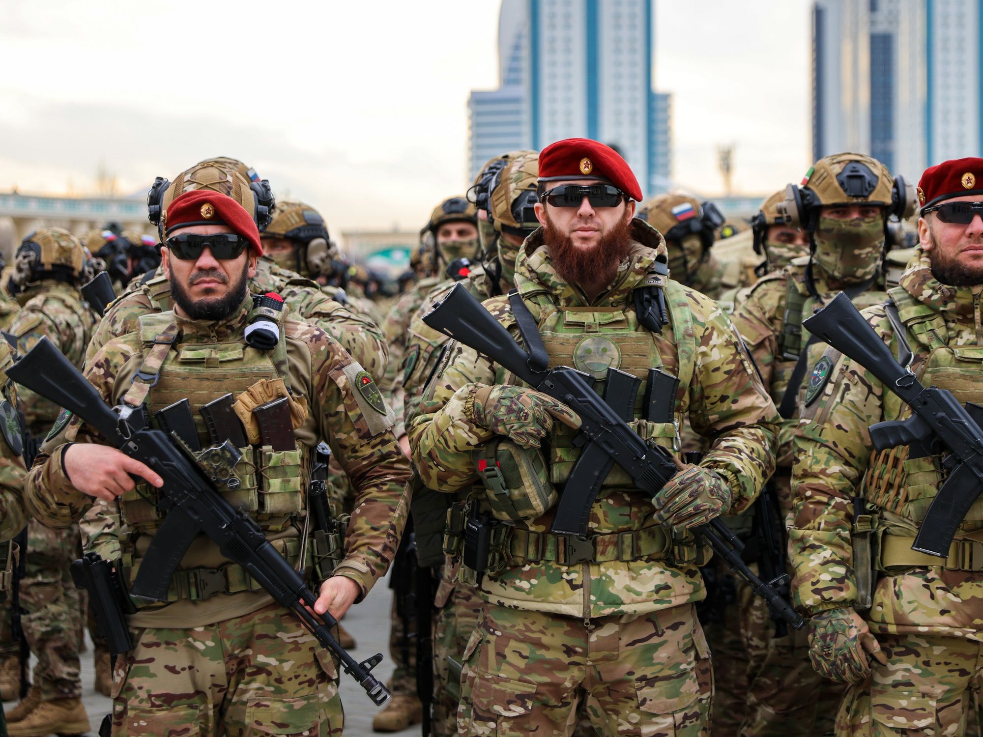 photo of three soldiers with automatic weapons and red berets