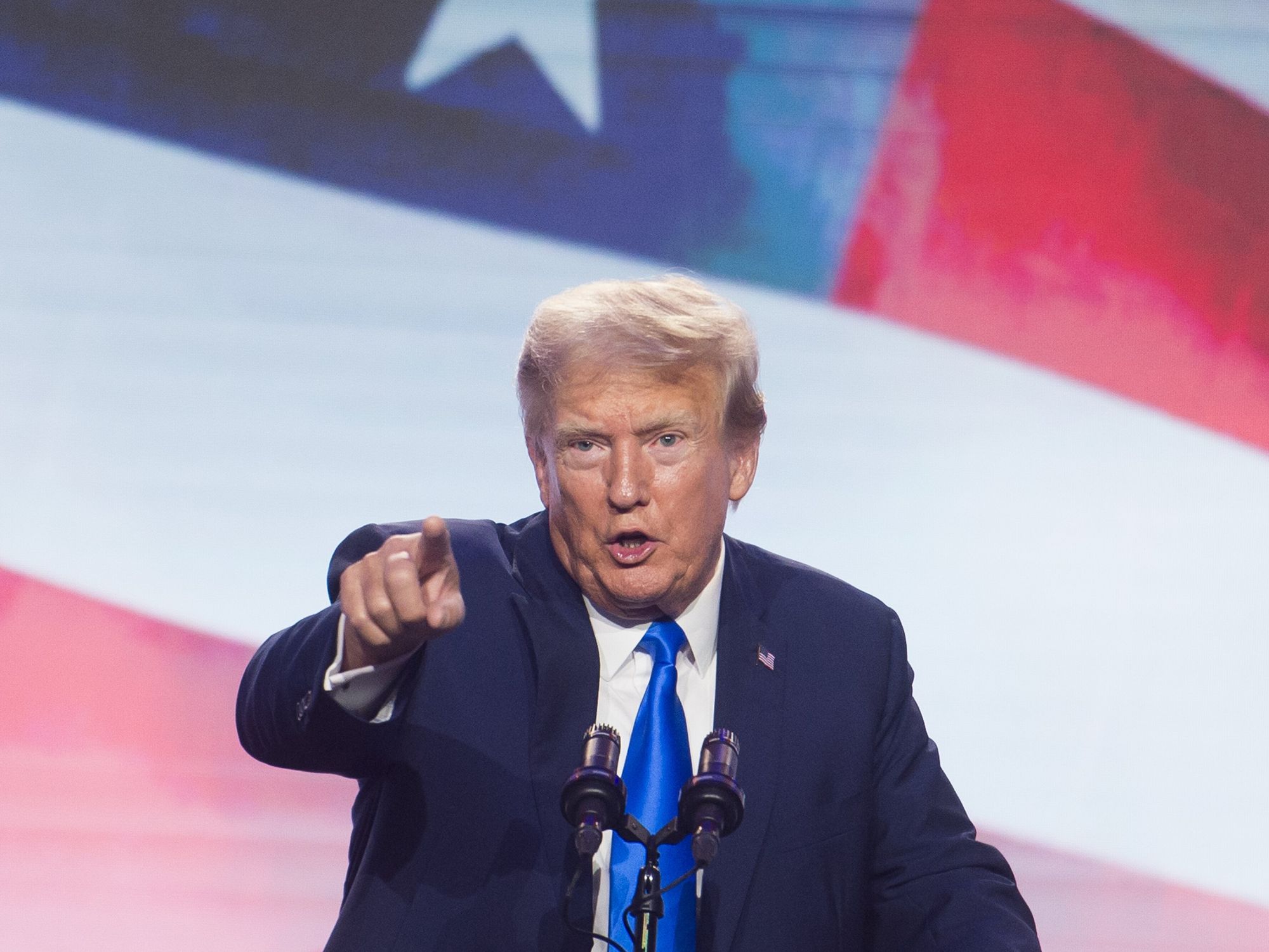 photo of trump pointing with a flag behind