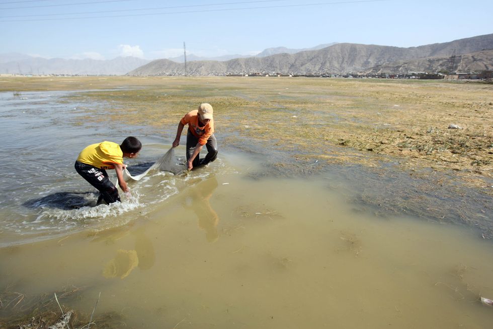 Photo of two boys fishing in a lake in Afghanistan