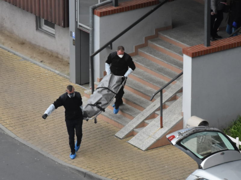 Photo of two funeral home workers carrying a deceased man in Wroclaw, Poland