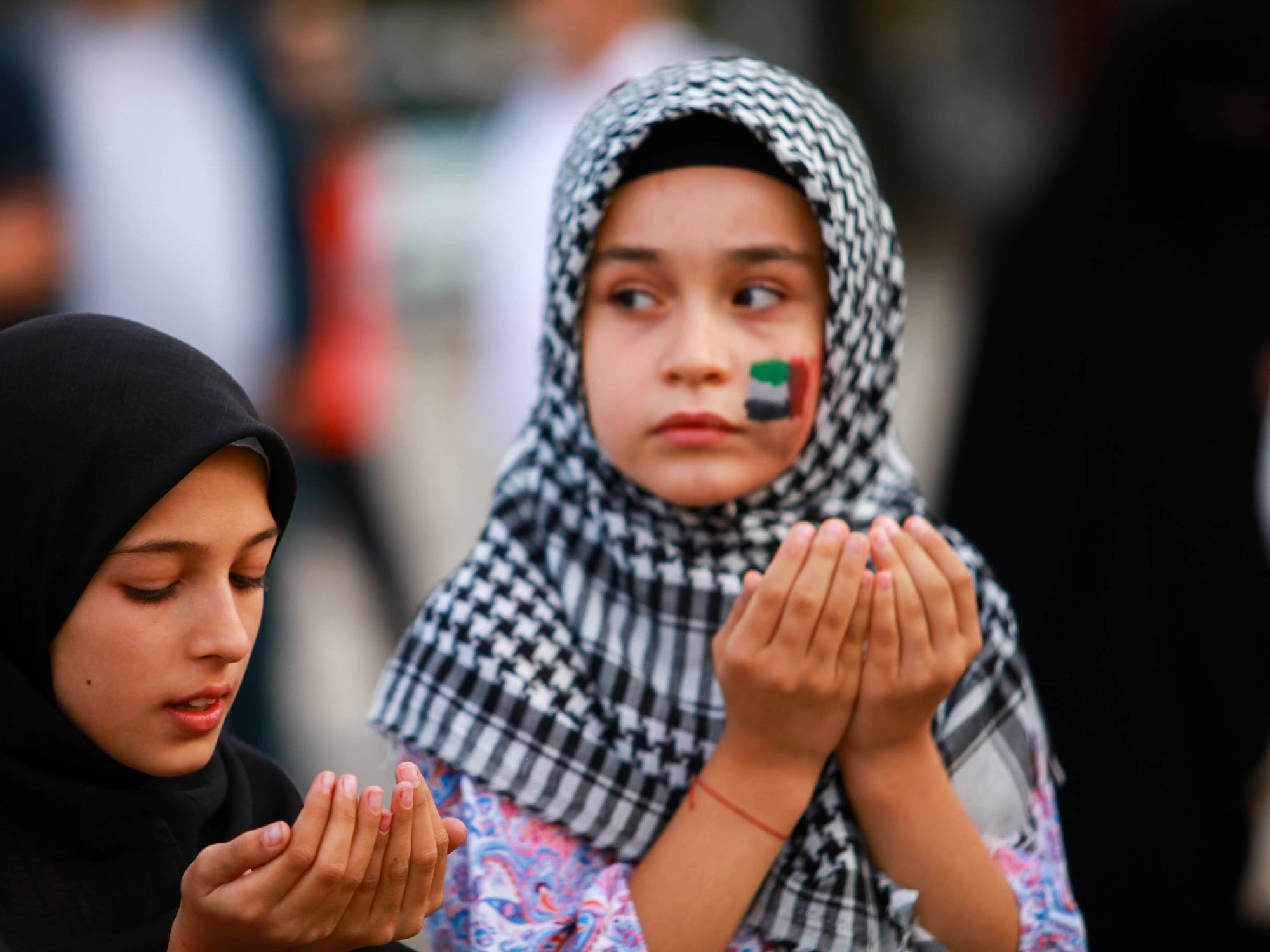 Photo of two girls praying during a Pro-Palestinian rally in Gaziantep, Turkey, on Oct. 8