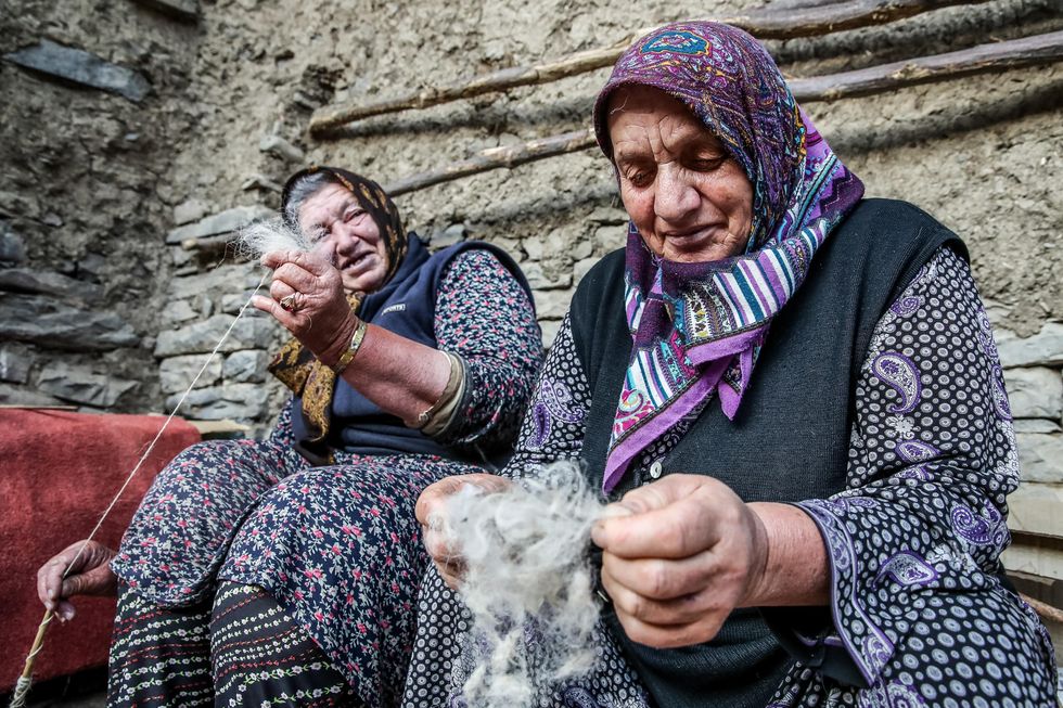 Photo of two indigenous women looking through sheep wool in Russia's Republic of Dagestan