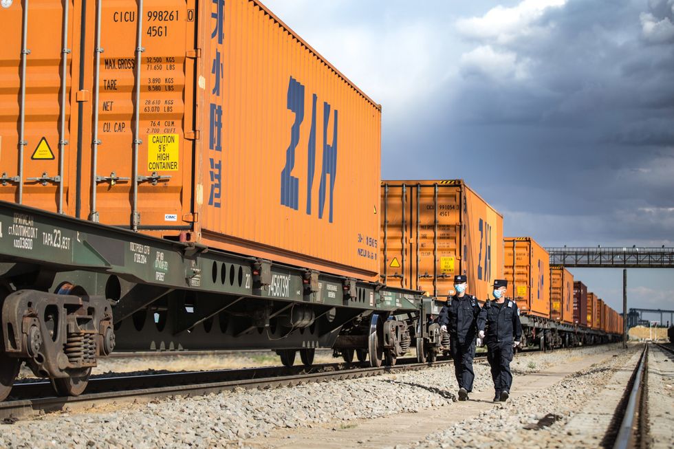 photo of two inspectors walking past a train freight line
