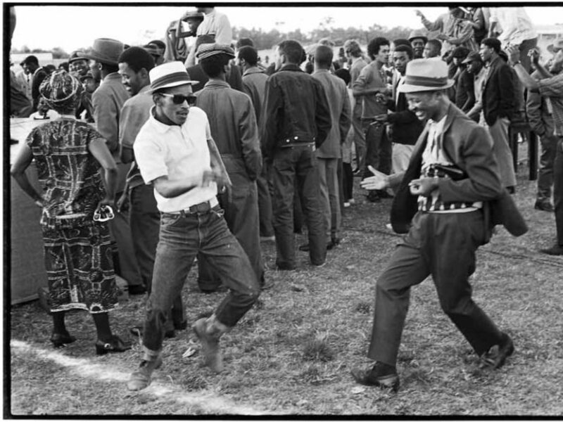 photo of two men dancing outside at a concert
