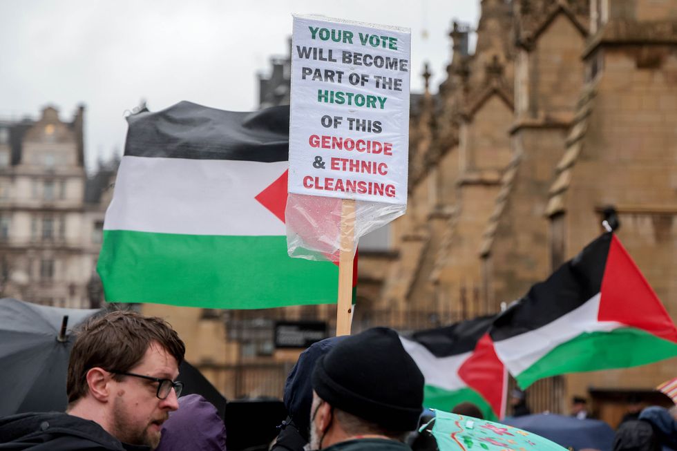 photo of two men holding up a sign against genocide and ethnic cleansing