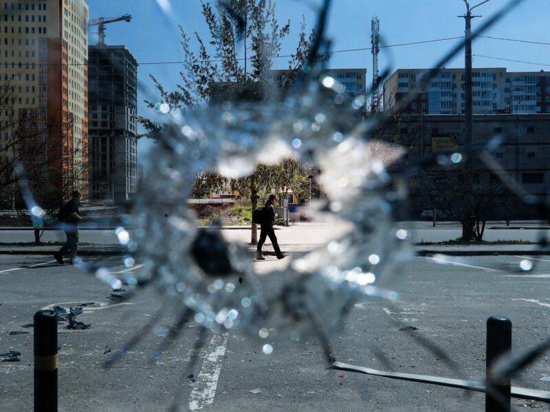 Photo of two men through a bullet hole on a window in Ukraine