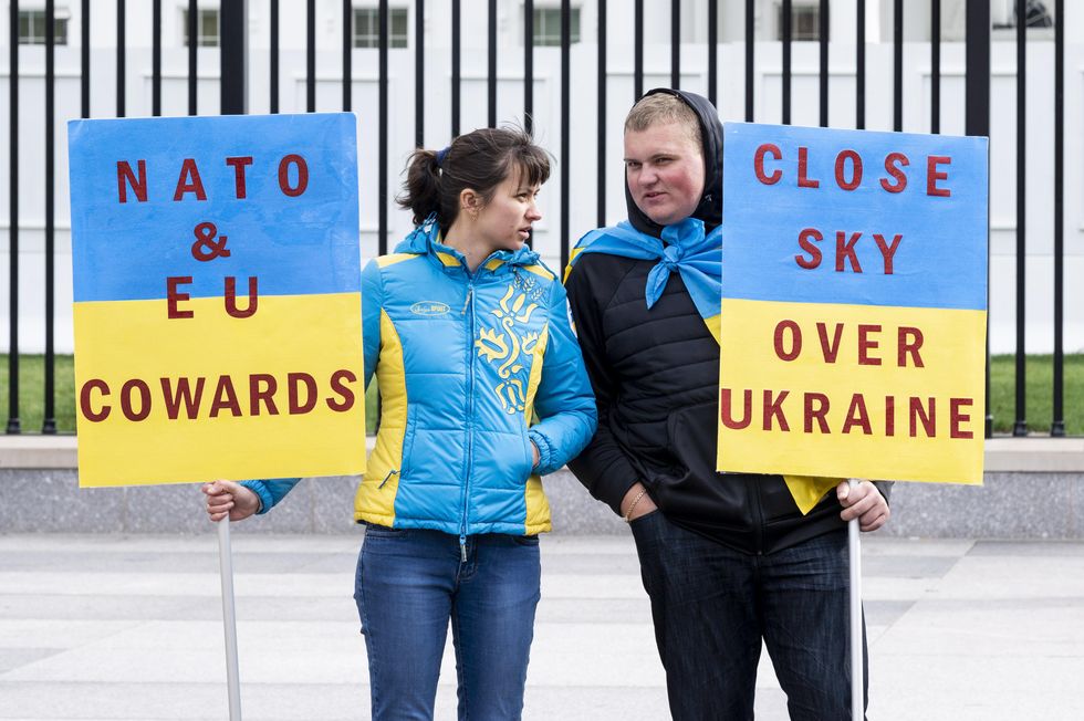 Photo of two people holding up signs in support of Ukraine