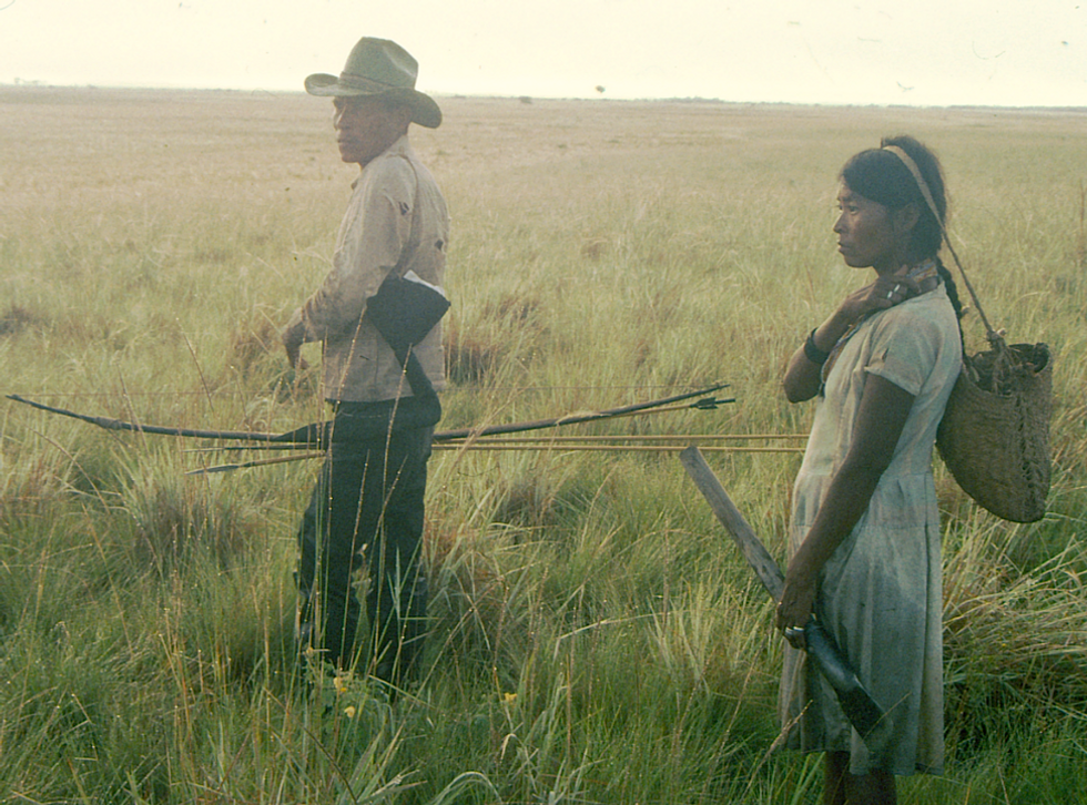 photo of two people hunting in a field with bows and arrows