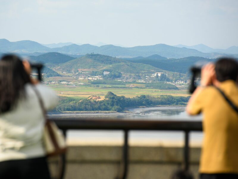 Photo of two people looking at the North Korean side of the Demilitarized Zone (DMZ) dividing the two Koreas through binoculars, from South Korea's Unification Observatory in Paju, north of Seoul.