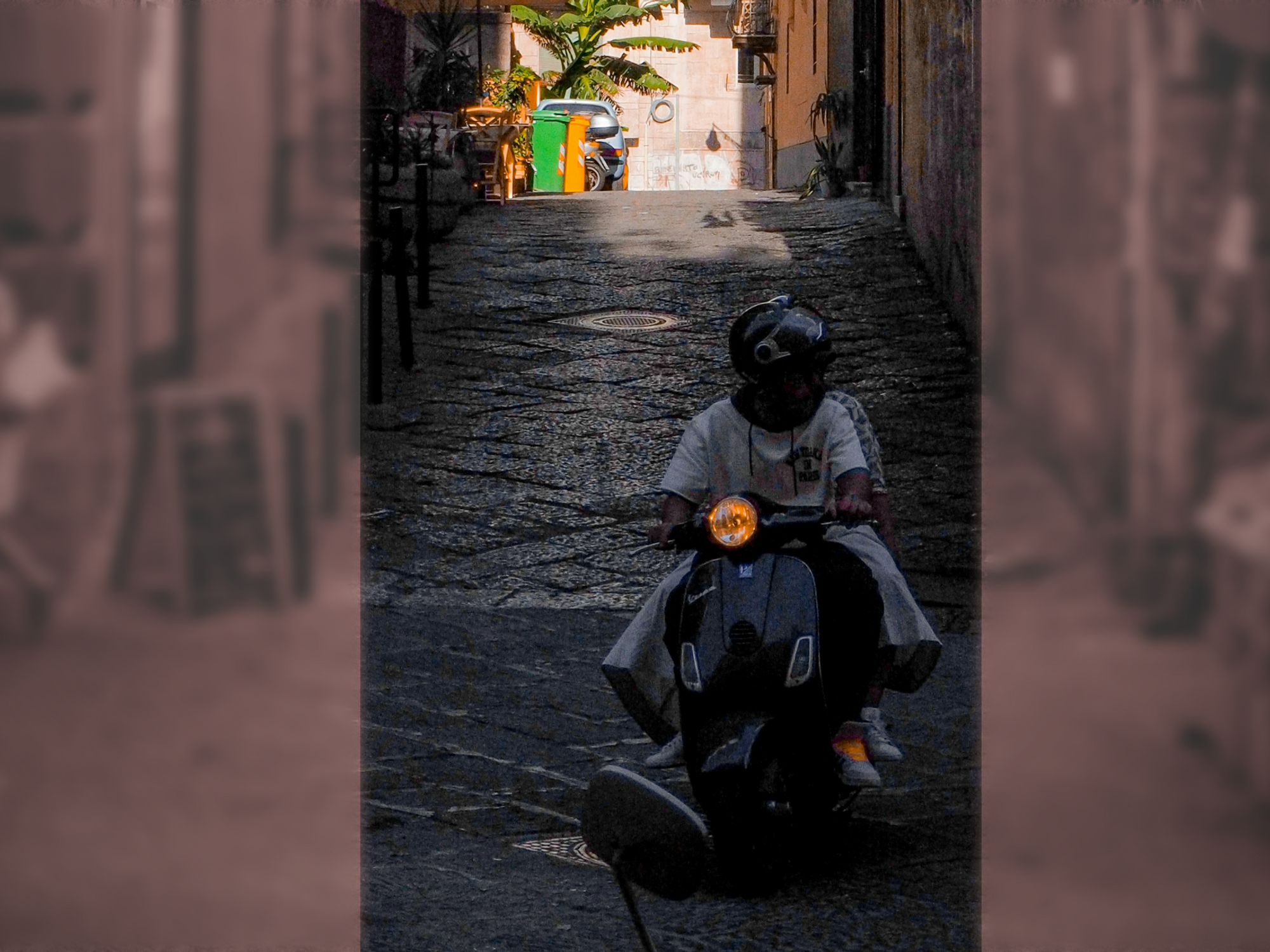 Photo of two people riding a moped on the streets of Naples, Italy