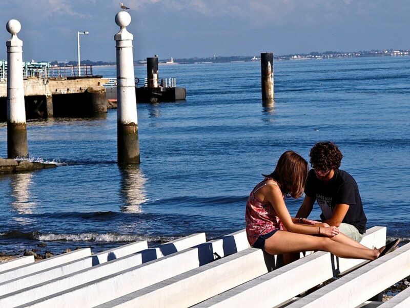 photo of two people talking on a dock