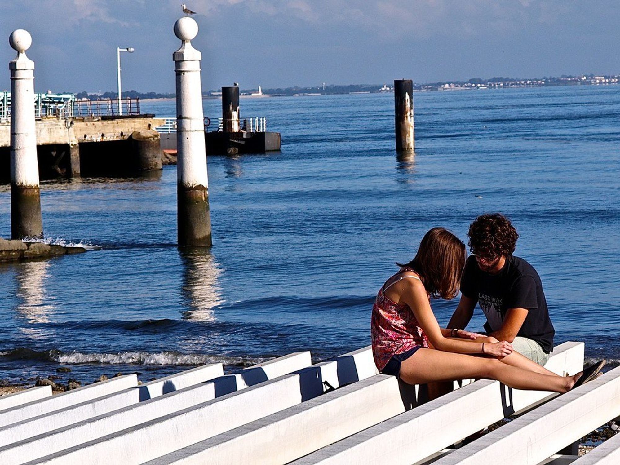 photo of two people talking on a dock