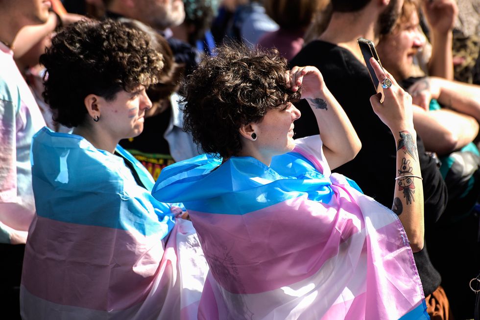 Photo of two people with transgender flags during the Transgender Day of Visibility demonstration in Rome​.