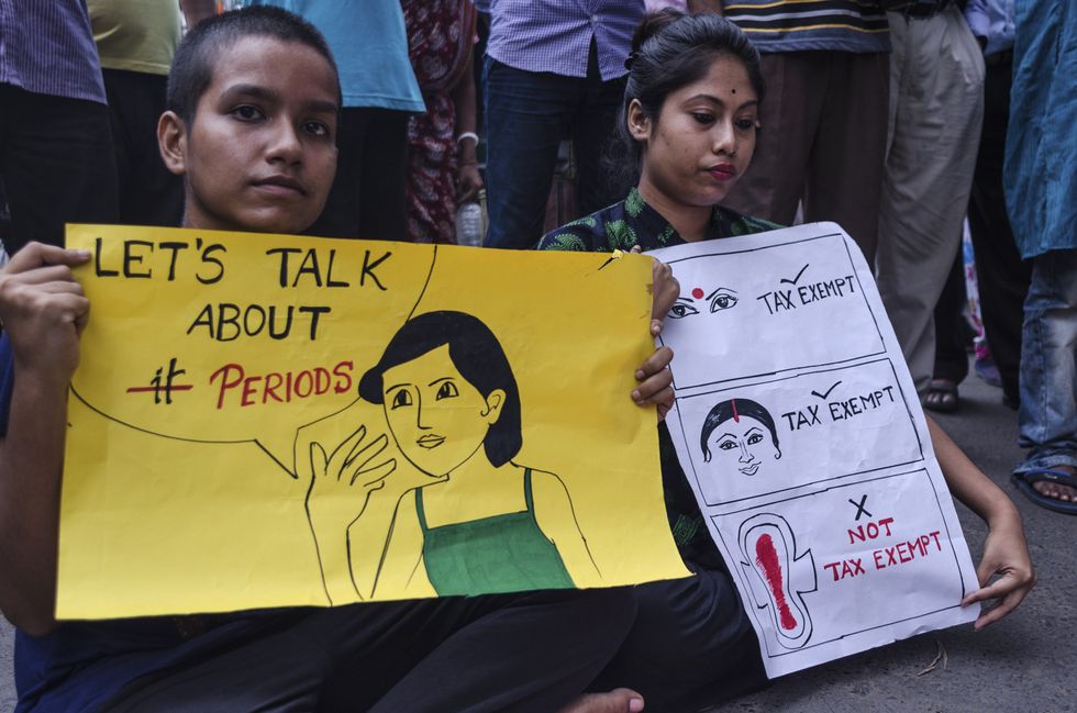 Photo of two protesters in India after the Modi government imposed a 12% tax on sanitary products
