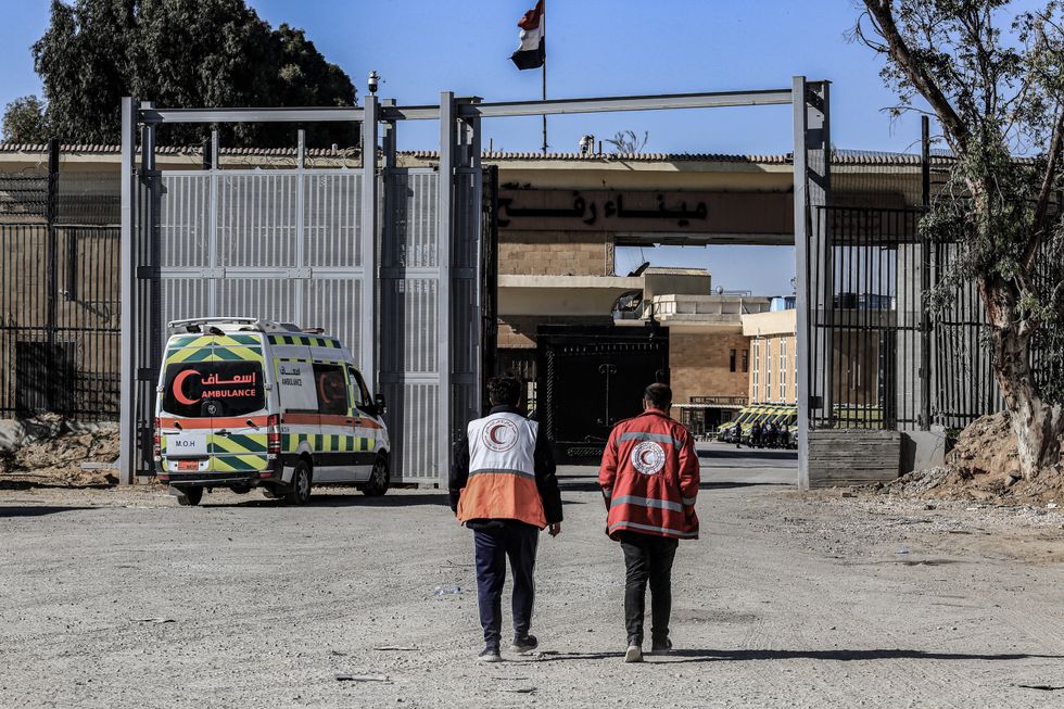 Photo of two Red Crescent workers walking toward the Rafah border crossing
