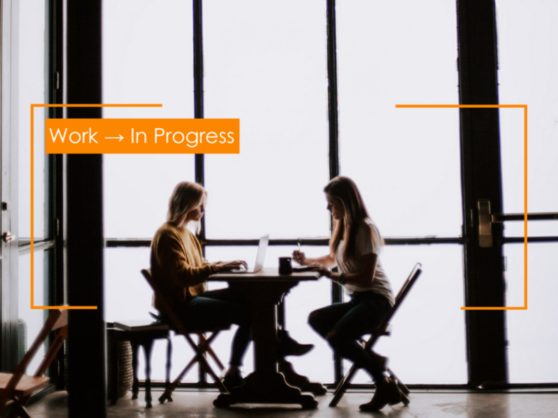 Photo of two women gathered around a table working