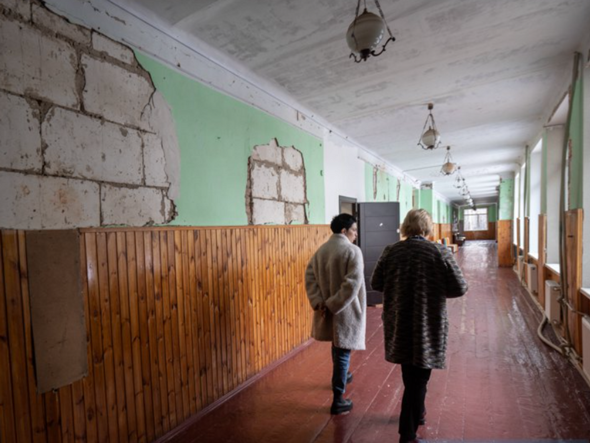 Photo of two women walking down a school hall in Novyi Bykiv, Ukraine