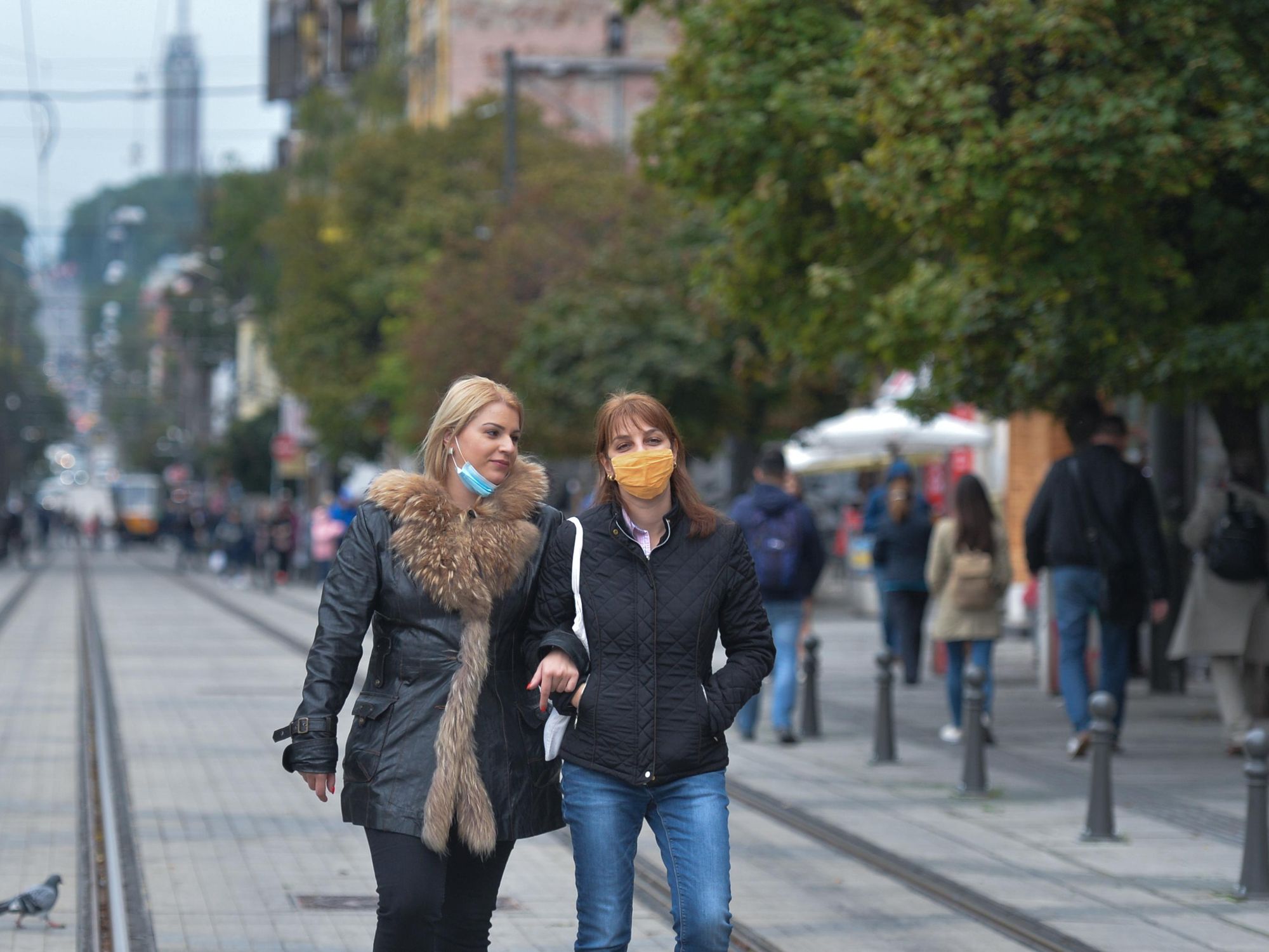 Photo of two women wearing COVID protective masks walking in the city center of Bulgaria's capital, Sofia