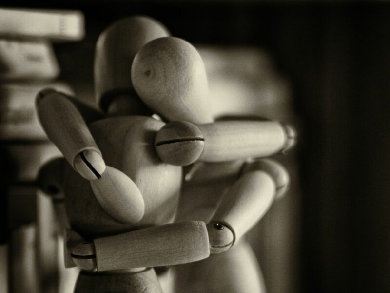 Photo of two wooden mannequins in an embrace