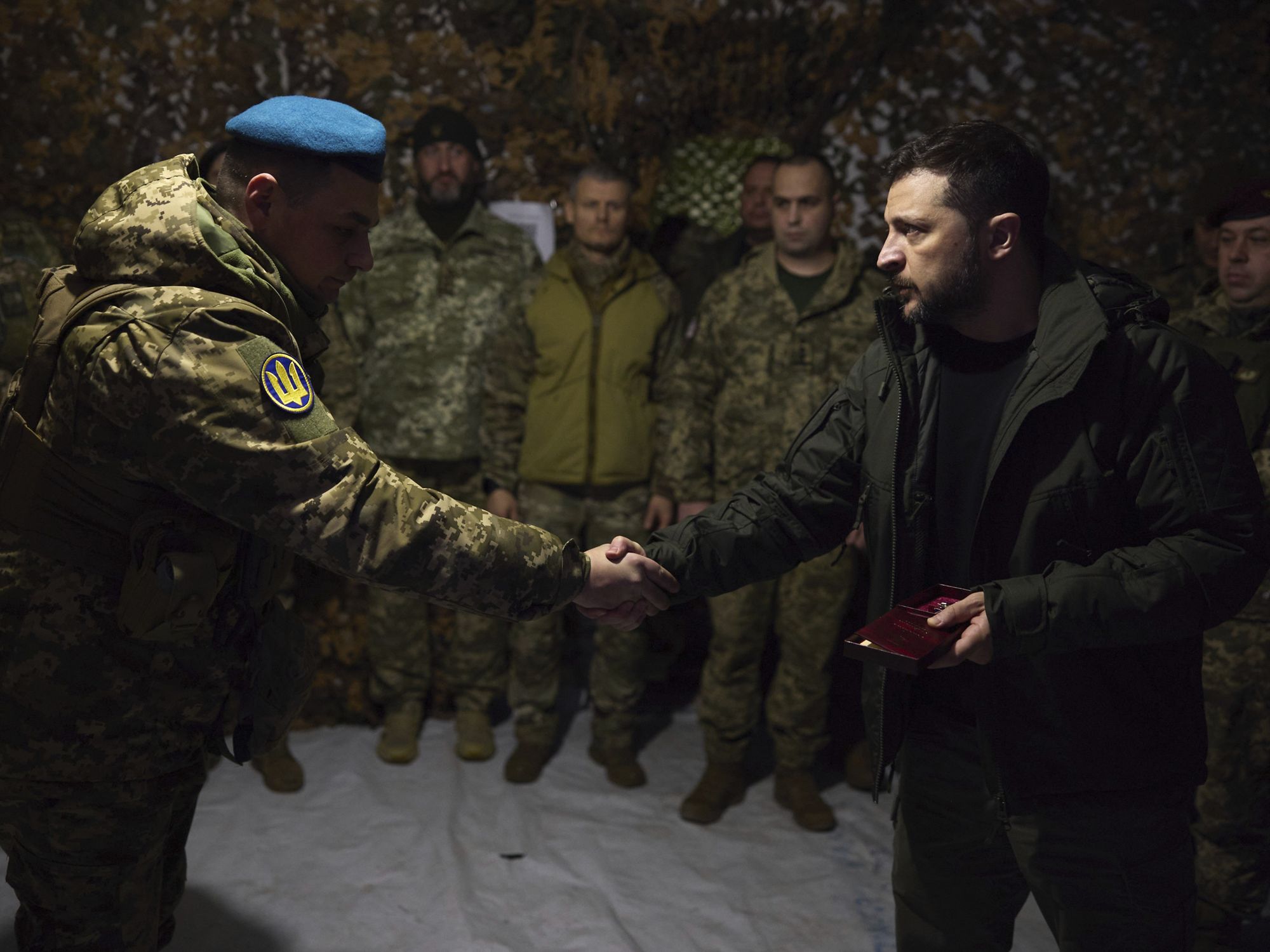 photo of Ukrainian President Volodymyr Zelensky shaking hands with a soldier