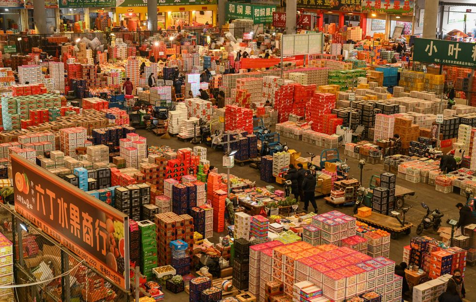 Photo of vendors stocking up on fruits at a wholesale market in Yiwu, China.