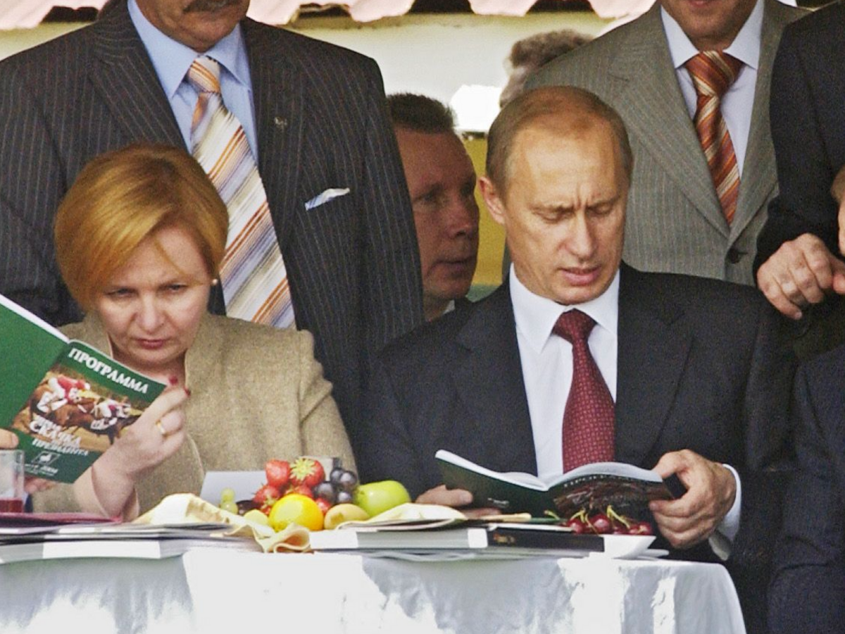 Photo of Vladimir Putin reading a book at a table with his wife Lyudmila