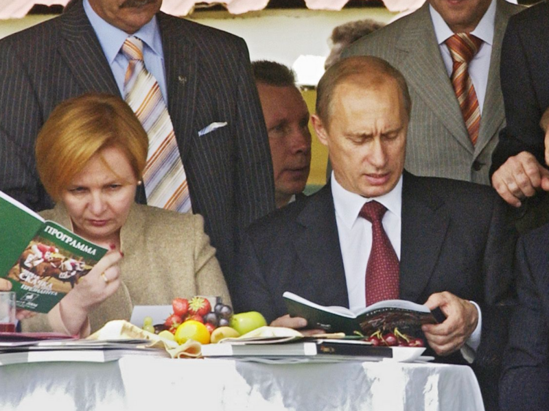 Photo of Vladimir Putin reading a book at a table with his wife Lyudmila