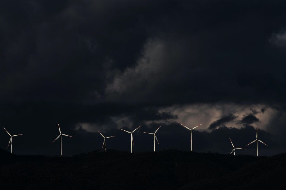 Photo of wind turbines in Montescudaio, Italy, as a storm is brewing