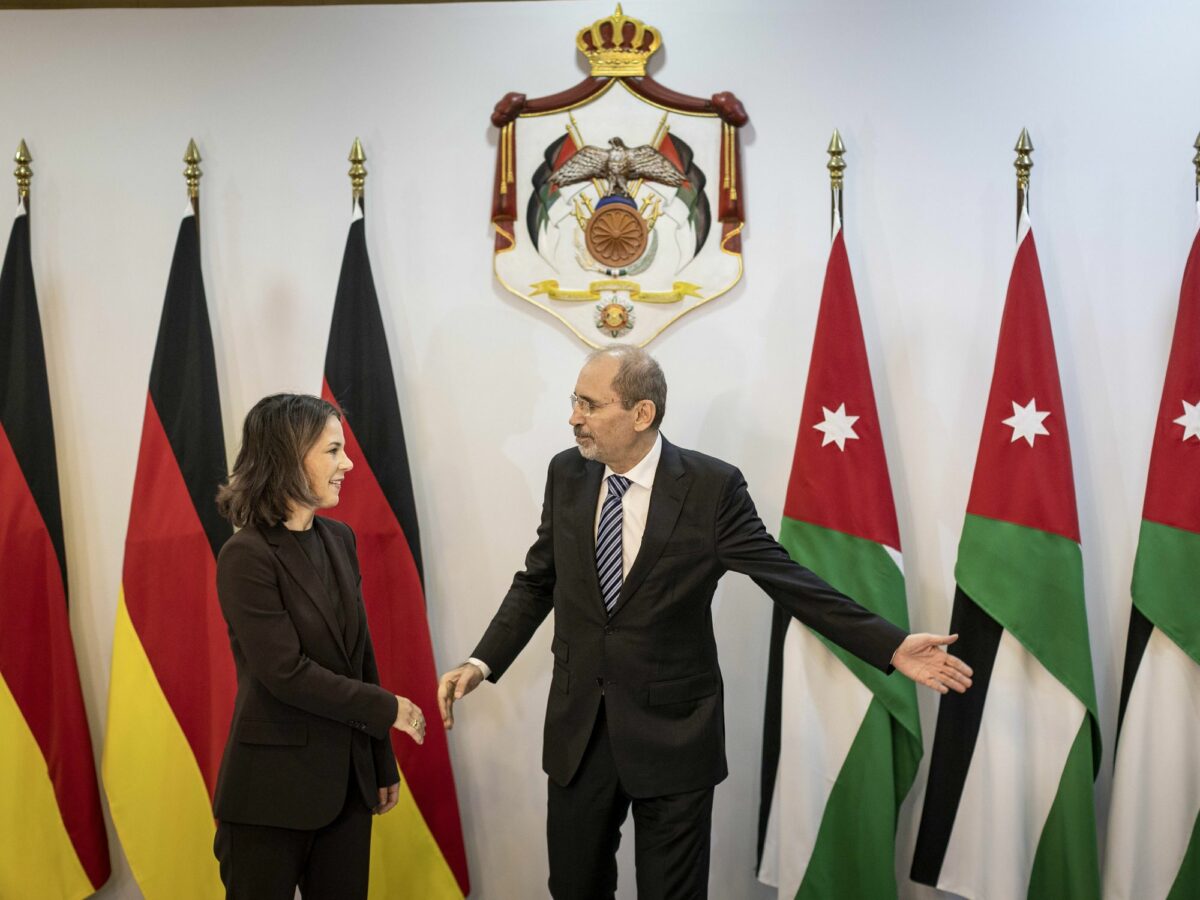 photo of woman and man diplomats in front of flags